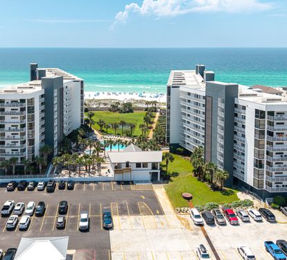 Modern beachfront property offering direct access to pristine white sands and stunning turquoise waters, with spacious grounds and convenient parking for guests.