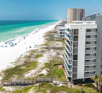 The property sits directly on pristine white sand with stunning turquoise waters stretching along the Gulf Coast. Steps from your door, you'll find beach access and nearby amenities in this vibrant coastal setting.