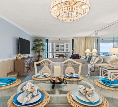 Your elegant dining space flows seamlessly into the living area, where ocean breezes drift through sliding doors onto your private balcony.