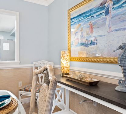 Enjoy your morning coffee at this charming coastal-themed dining nook, where ocean artwork and nautical touches create a serene beachside atmosphere.