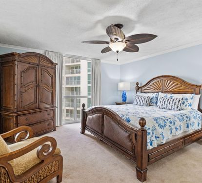Your peaceful master bedroom features tropical hardwood furniture and ocean-inspired blues, with gentle breezes from the ceiling fan creating your perfect sleep sanctuary.