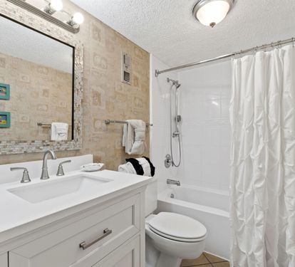 Step into your elegant bathroom featuring marble touches, fresh towels, and a relaxing tub-shower combo for your comfort.