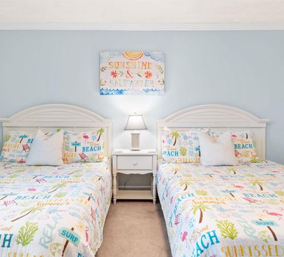 Drift into dreams in this bright beach-themed bedroom with twin beds and cheerful coastal decor that whisks you to summer bliss.
