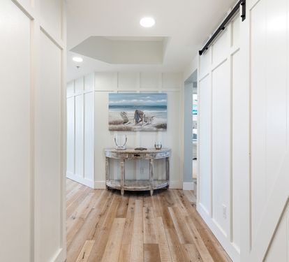 Step into your welcoming foyer where coastal art and warm wood floors create an instant sense of home and relaxation.
