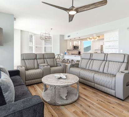 Unwind in your spacious living room featuring plush leather recliners, a cozy sectional sofa, and elegant coastal décor throughout this bright, airy space.