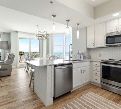 Your stunning oceanfront kitchen features premium appliances and granite counters, while floor-to-ceiling windows frame breathtaking sea views for memorable coastal cooking.