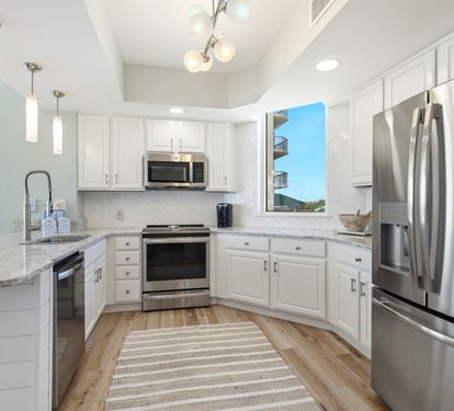 Your gourmet kitchen features granite countertops, stainless steel appliances, and a bright window bringing in natural light.
