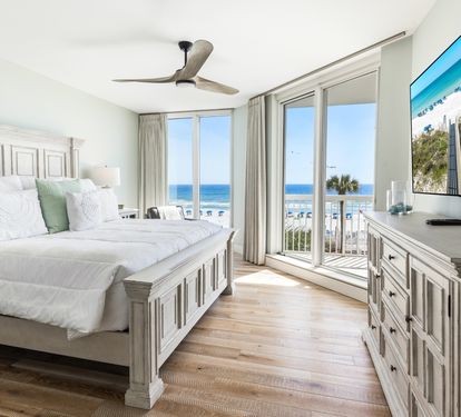 Wake up to breathtaking ocean views from your serene bedroom, where morning light dances across pristine white linens.