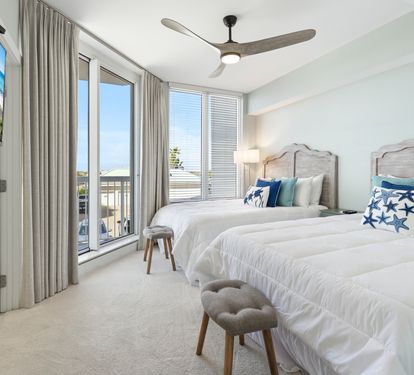 Drift into restful sleep in your coastal-inspired twin bedroom, where crisp white linens and ocean blues create pure serenity.