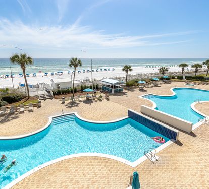 Stunning beachfront resort with expansive pool complex featuring connecting pools, waterfront dining, and direct beach access with pristine white sand.