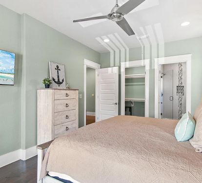 Spacious primary king suite with coastal décor, a Smart TV, and direct access to the private balcony.