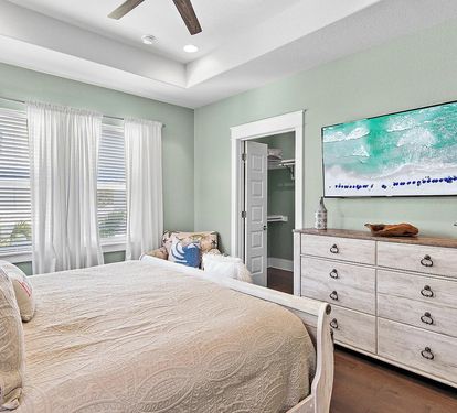 Relax in the spacious king bedroom featuring coastal décor, ample storage, and an attached ensuite bath.