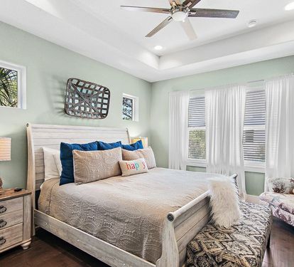 A peaceful upstairs king retreat with stylish furnishings, ceiling fan, and private ensuite—perfect for unwinding after a day at the beach.