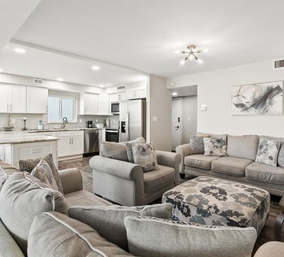 Sink into plush gray seating while your group gathers in this bright open-concept space connecting kitchen and living areas.