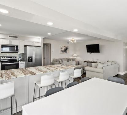 Relax in your spacious open-concept living area with a modern kitchen, comfortable seating, and entertainment center perfect for your getaway.