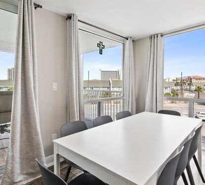 Gather around your spacious dining table with panoramic windows showcasing the coastal neighborhood, where natural light fills every shared meal.