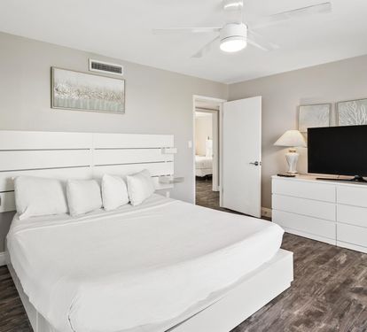 Drift into restful sleep in your serene bedroom featuring crisp white linens and modern amenities for ultimate comfort.