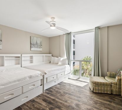 Relax in your bright bedroom with twin beds and storage, plus a cozy chair by the window.