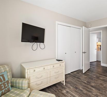 Relax in your cozy living space with plaid seating, wall-mounted TV, and ample storage in this comfortable dresser.
