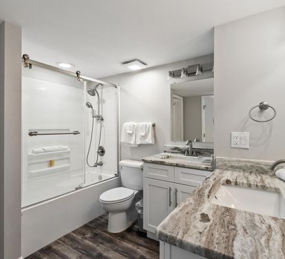 Step into your spa-like bathroom featuring elegant marble countertops, modern fixtures, and fresh towels awaiting your arrival.