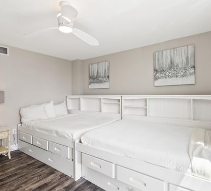 Sleep comfortably in this charming bedroom featuring twin beds with built-in storage and soothing neutral décor that creates your perfect retreat.