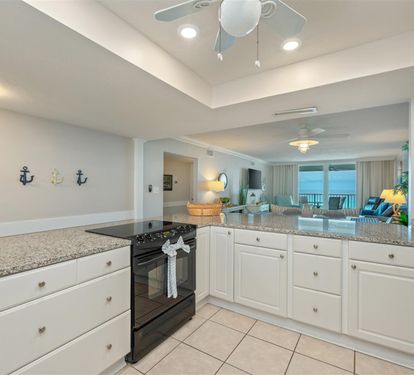 Your gourmet kitchen features granite countertops, full appliances, and nautical touches, opening to a living space with stunning sea views.