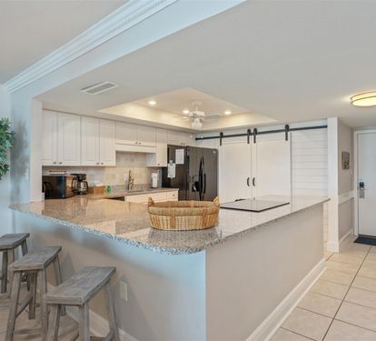 Your fully equipped kitchen features granite countertops, modern appliances, and a breakfast bar where you can enjoy morning coffee.