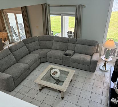 Sink into your spacious sectional sofa with stunning waterfront views through glass doors leading to your private outdoor seating area.