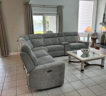 Unwind in your spacious living room with plush sectional seating and stunning lake views through oversized windows.