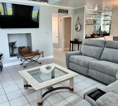 Your nautical-themed retreat features plush seating, a large flat-screen TV, and a warm fireplace for cozy evenings.