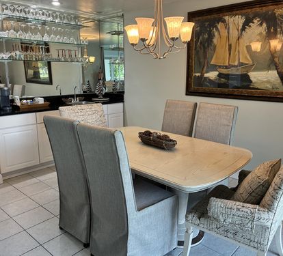 Gather around your elegant dining table for memorable meals while admiring nautical artwork and sparkling glassware displays.
