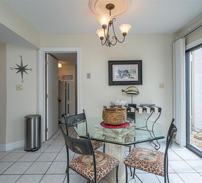 Your dining space features a glass-top table and elegant chandelier, creating the perfect spot for memorable meals together.