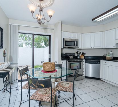Your bright kitchen features stainless steel appliances and a glass dining table where you'll enjoy meals with garden views.