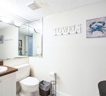 Your coastal-themed bathroom features warm nautical touches, with a convenient towel hook and vanity mirror for your daily routine.