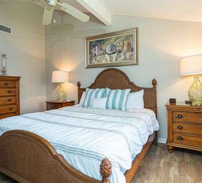 Sink into coastal comfort in your serene bedroom, where wicker furnishings and soft ocean-inspired linens create the perfect retreat after sun-filled days.