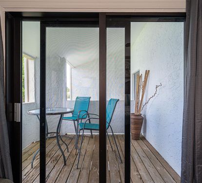 Step out to your private balcony and enjoy morning coffee at your intimate bistro table surrounded by calming blue.