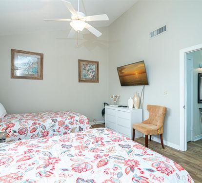 Unwind in your peaceful retreat with twin beds, fresh coastal decor, and modern amenities for your perfect getaway.