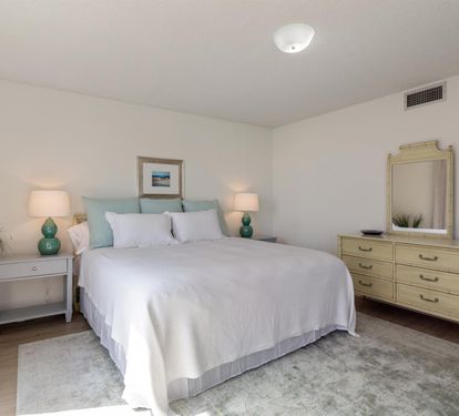 Sink into crisp white linens and let the soothing mint accents calm your mind in this thoughtfully designed bedroom retreat.