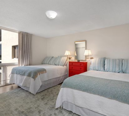 Unwind in your bright twin bedroom featuring soft blue accents and cheerful red dresser details.