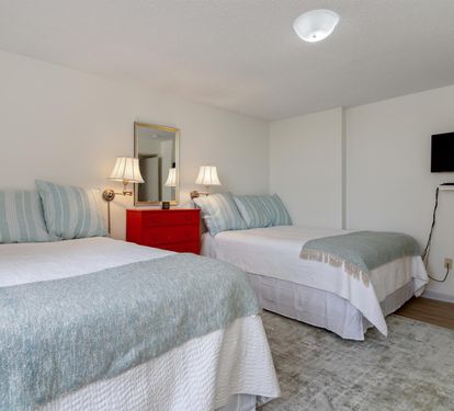 Relax in your peaceful twin bedroom with soft sea-foam linens, cozy reading lamps, and entertainment on the wall-mounted TV.