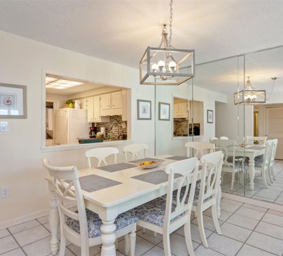 Gather around your spacious dining table for memorable meals, with elegant lighting and a seamless flow to the fully-equipped kitchen beyond.