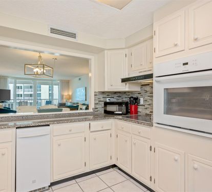 Your spacious kitchen features granite counters, white cabinetry, and a pass-through to the bright living area.