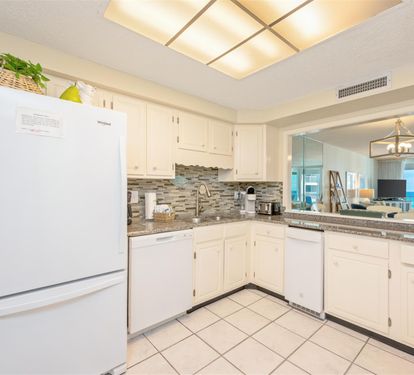 Your modern kitchen awaits with granite counters and white cabinetry, perfect for preparing meals while enjoying the open-concept flow.