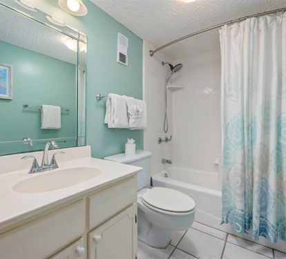 Step into your serene bathroom with soothing aqua walls, crisp white vanity, and fresh towels waiting for you.