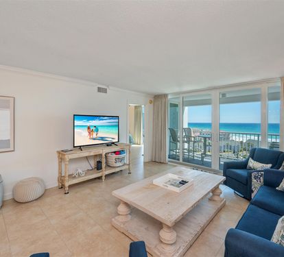 Sink into plush blue sofas while enjoying stunning ocean views through floor-to-ceiling windows in your coastal retreat.