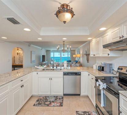 Your elegant kitchen flows seamlessly into a bright living space with stunning ocean views, featuring granite countertops and premium stainless appliances.