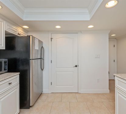 Your fully equipped kitchen awaits with elegant white cabinetry, granite counters, and modern appliances—perfect for preparing memorable meals during your stay.