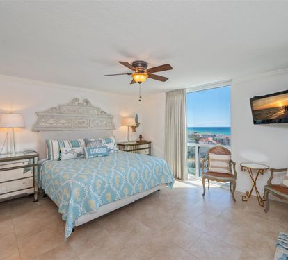 Wake up to stunning ocean views from your bright, coastal-themed bedroom with elegant décor and private balcony access.