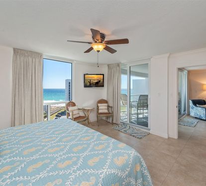 Wake up to stunning ocean views from your coastal bedroom, complete with a private balcony and soothing sea breeze from the ceiling fan.