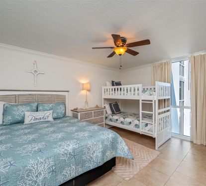 Your coastal-themed bedroom offers peaceful rest with a queen bed and bunk beds, perfect for families seeking ocean-inspired comfort together.